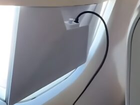 Passageiro operando uma antena da Starlink em voo da Azul com cabos conectados