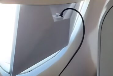 Passageiro operando uma antena da Starlink em voo da Azul com cabos conectados