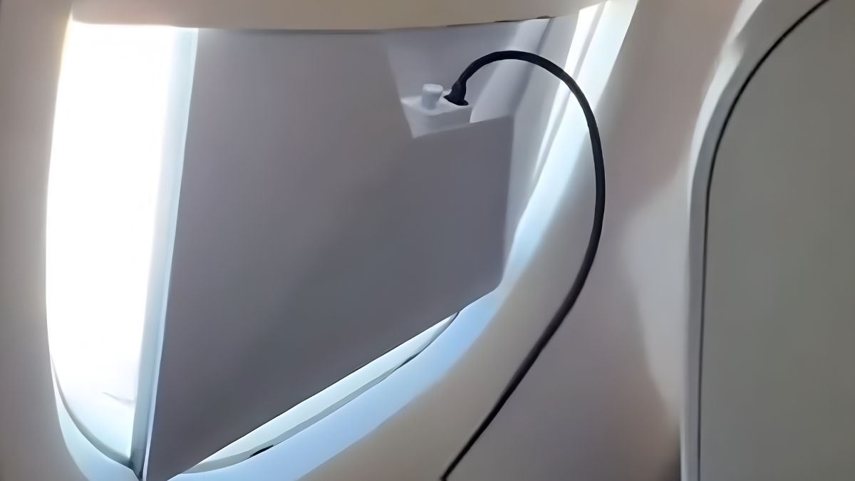 Passageiro operando uma antena da Starlink em voo da Azul com cabos conectados